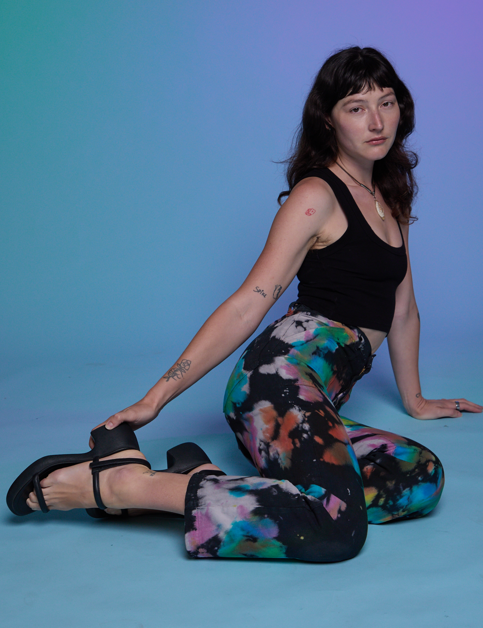 Alex is wearing Work Pants in Rainbow Magic Waters and black Cropped Tank