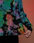 Magic Waters Long Sleeve Burly Tee in Rainbow bottom close up with Alex tugging on the hem
