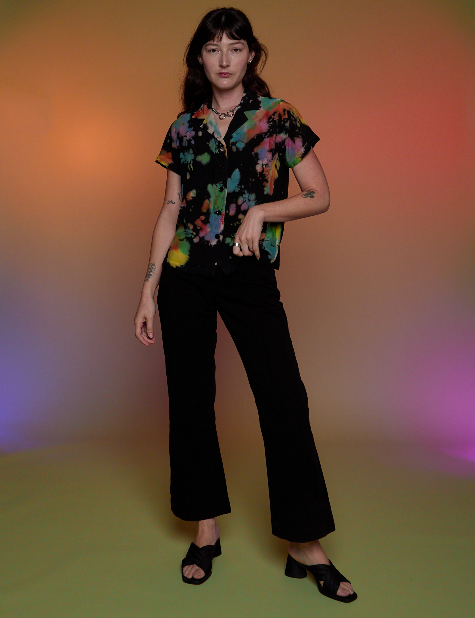 Alex is wearing Pantry Button-Up in Rainbow Magic Waters and black Western Pants