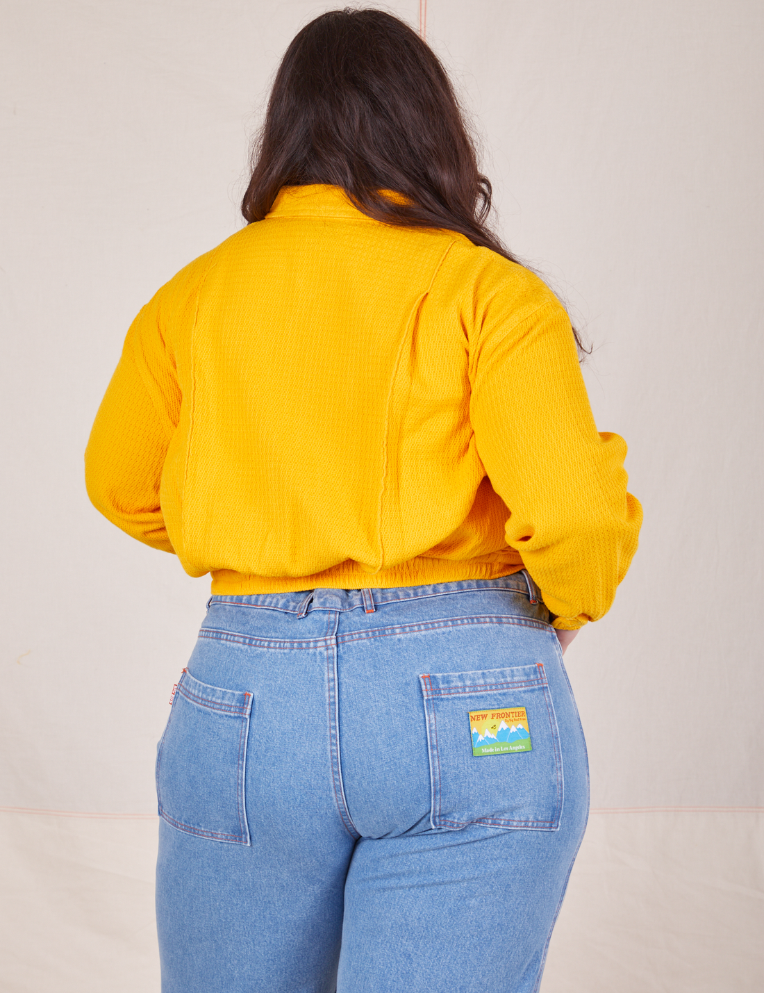 Back view of the Ricky Jacket in Sunshine Yellow worn by Ashley