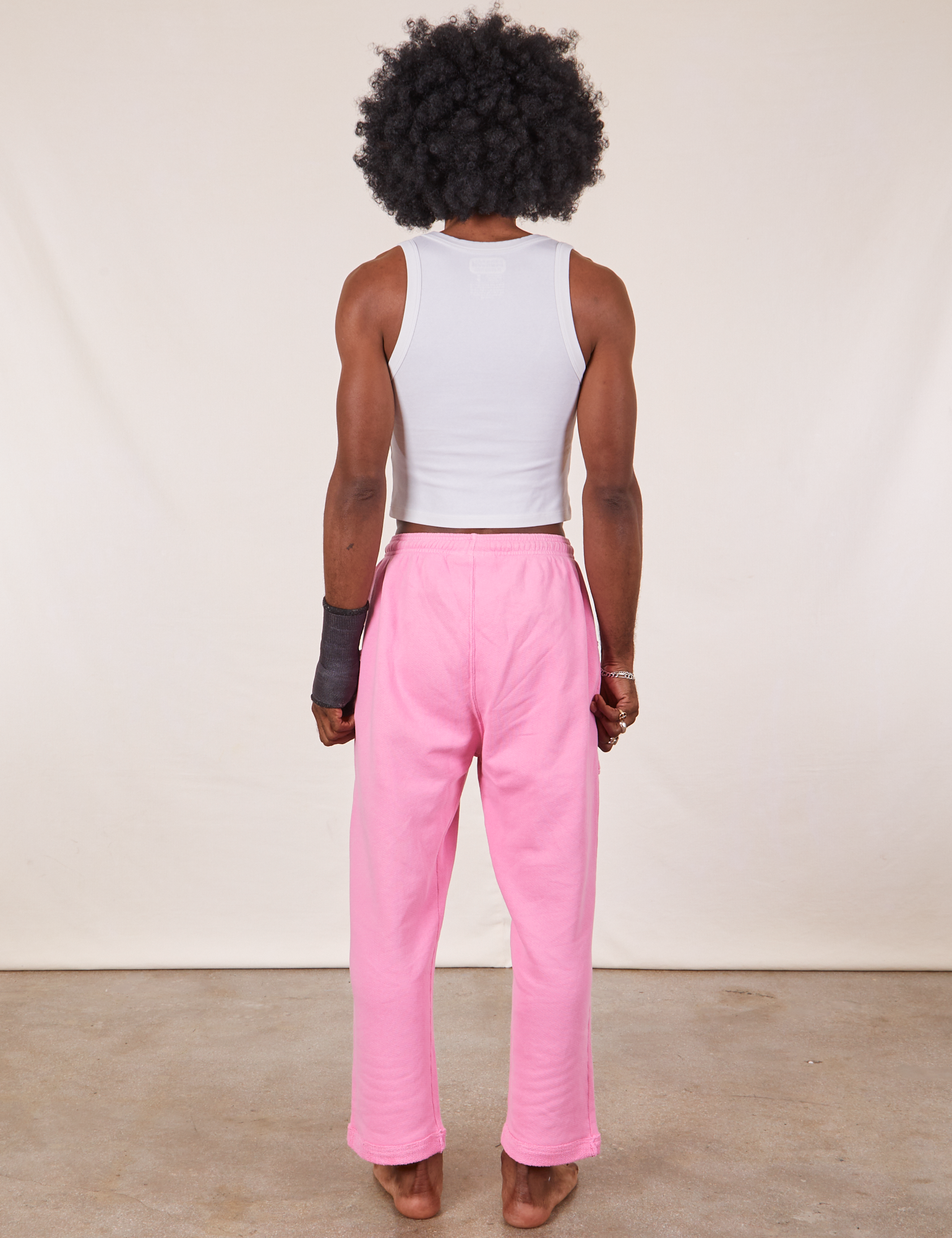 Back view of Cropped Rolled Cuff Sweatpants in Bubblegum Pink and vintage off-white Cropped Tank Top on Jerrod