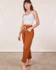 Angled view of Cropped Rolled Cuff Sweatpants in Burnt Terracotta and vintage off-white Cami on Alex