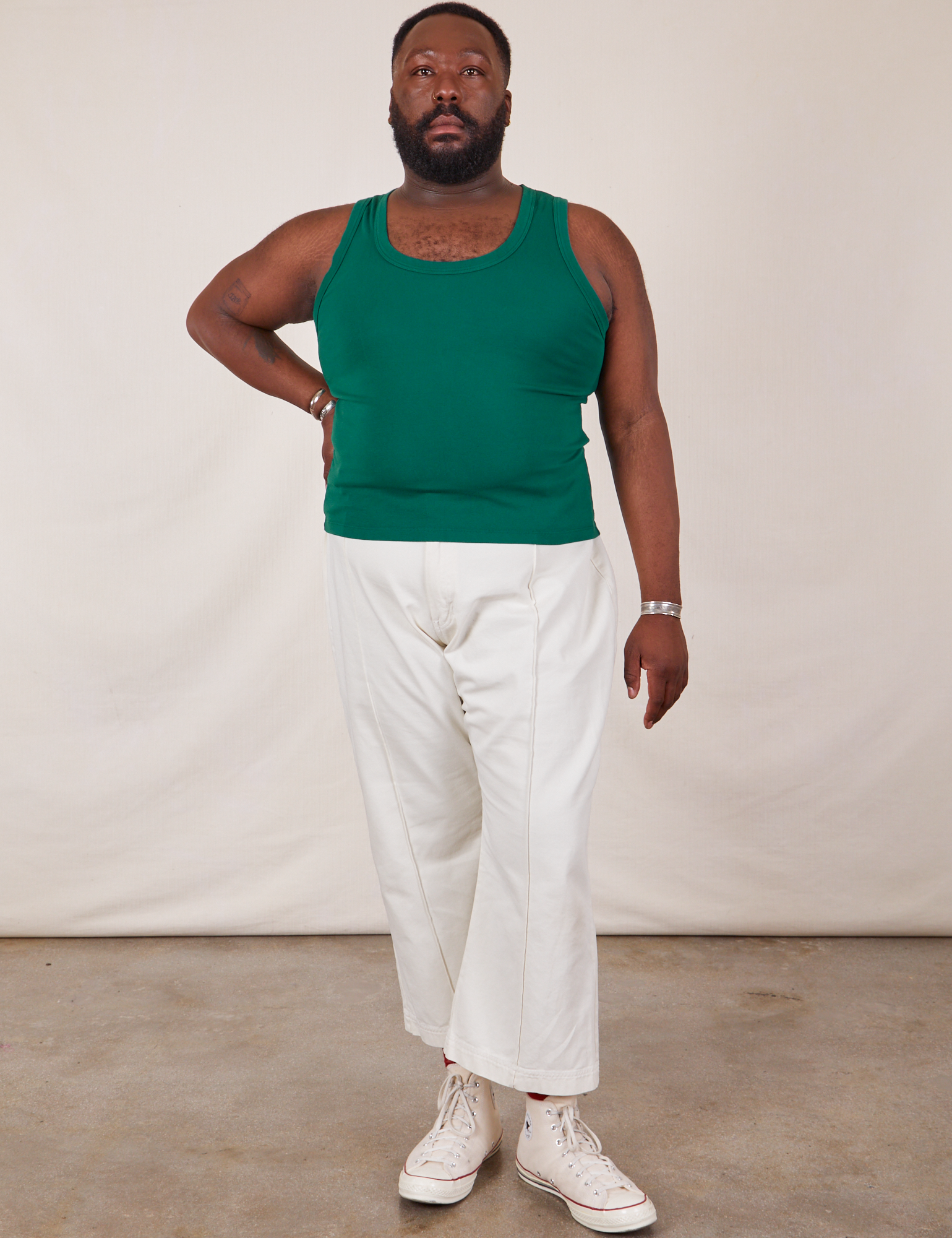 Elijah is 6’0 and wearing 3XL Tank Top in Hunter Green paired with vintage tee off-white Western Pants