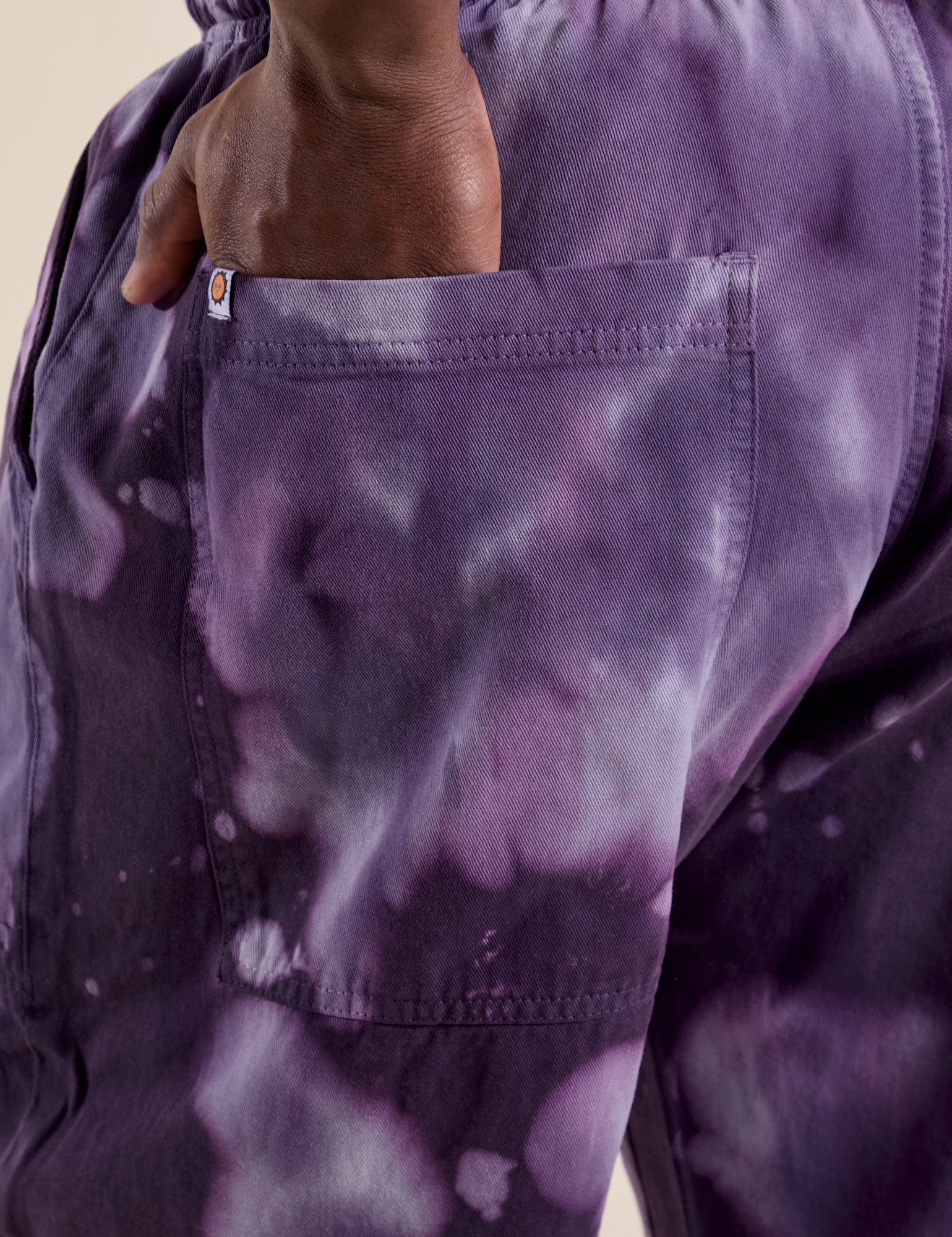 Close up of Demi's hand in the back pocket of Magic Waters Drop Pocket Pants in Dark Lavender
