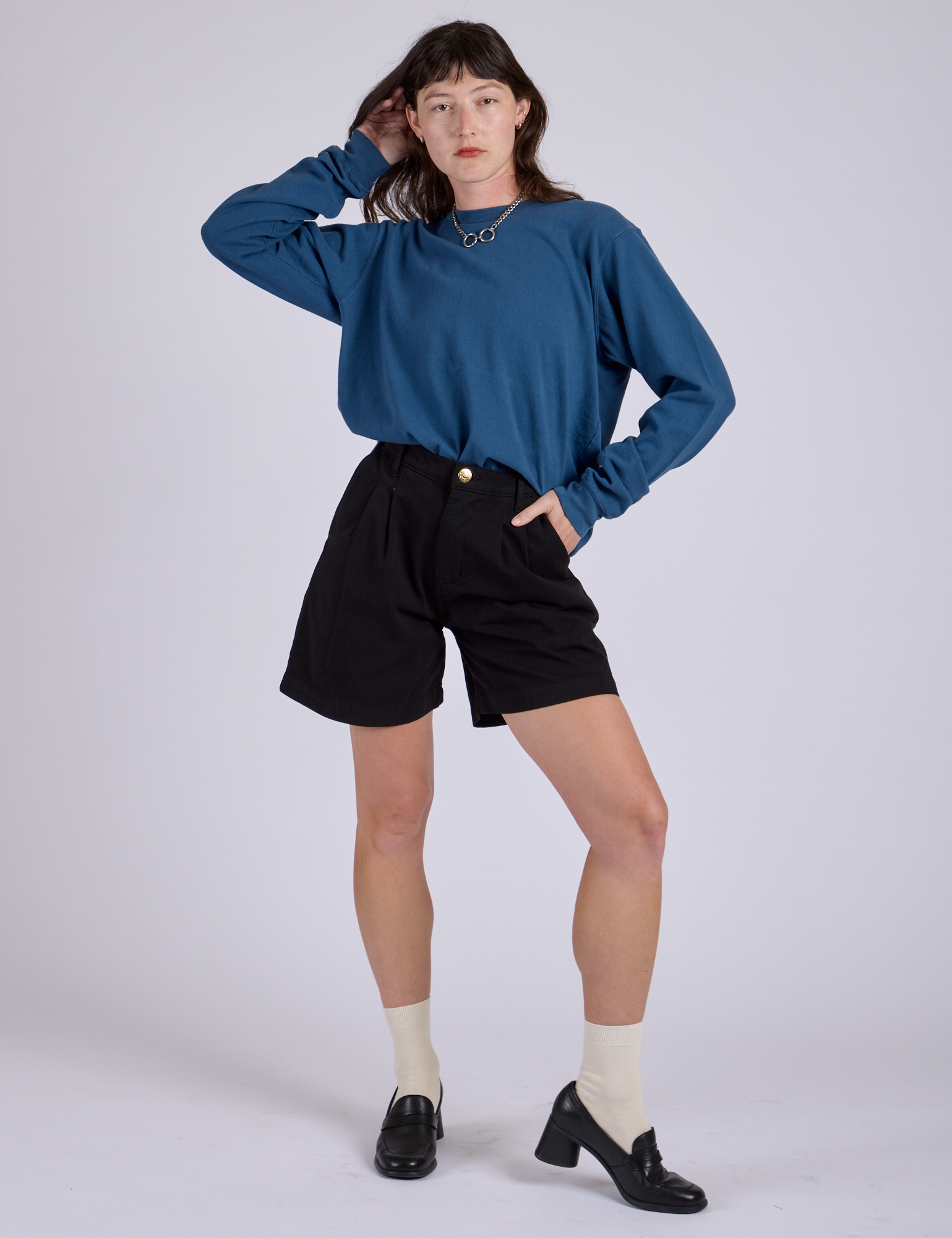 Alex is wearing Pleated Trouser Shorts in Basic Black and Long Burly Tee in French Blue