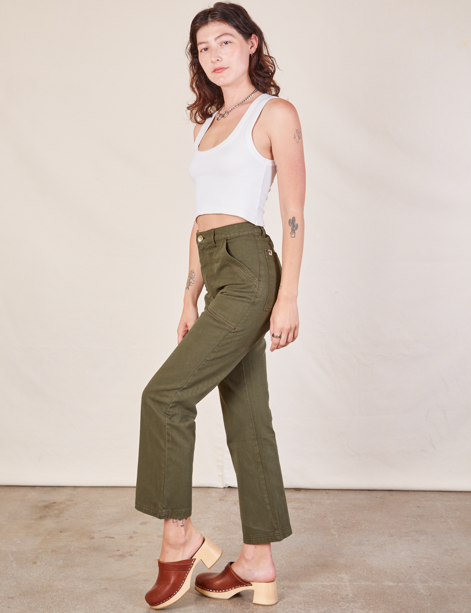 Side view of Work Pants in Surplus Green and Cropped Tank in vintage tee off-white on Alex