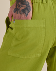 Close up of Jesse's hand in the back pocket of Work Pants in Gross Green