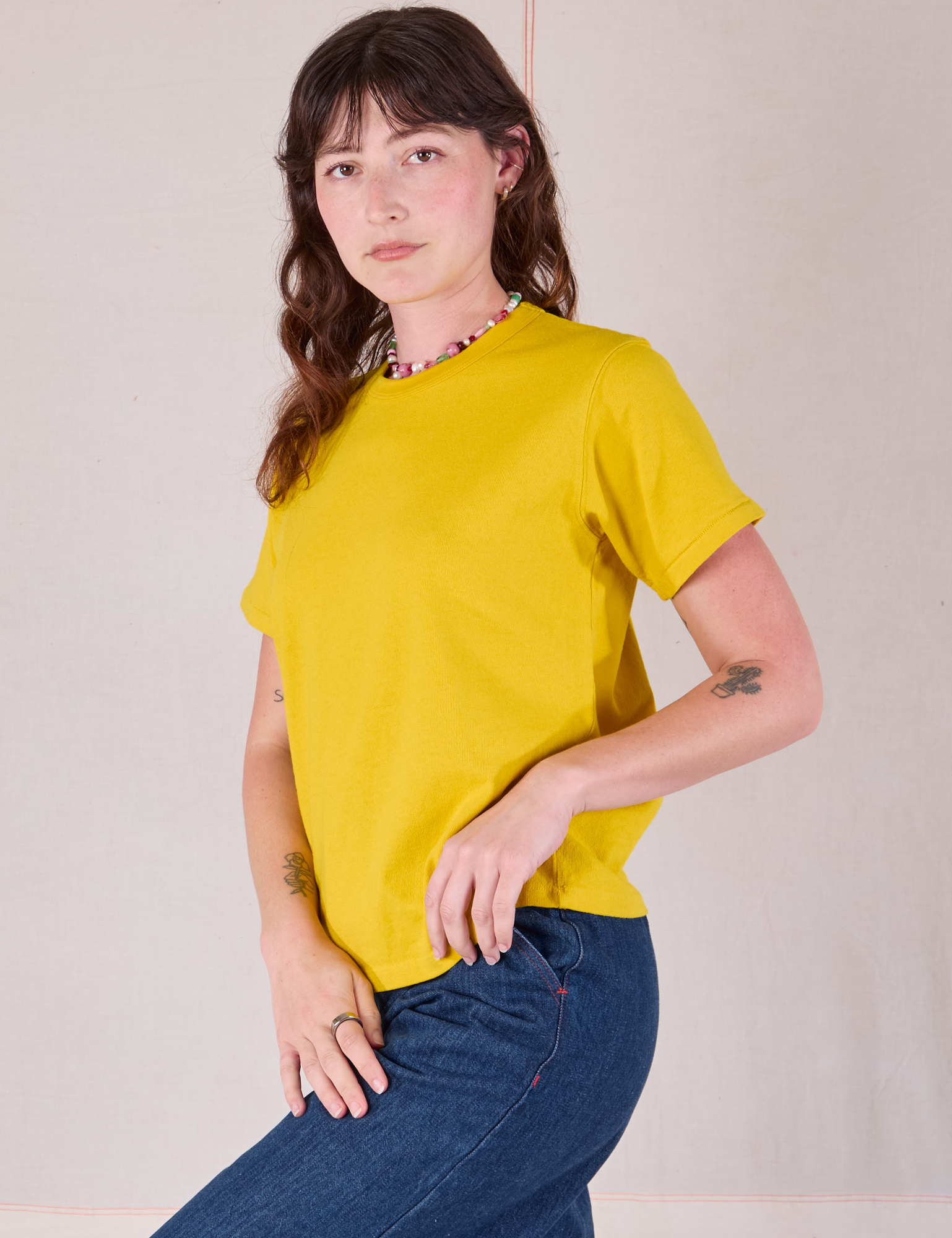 Burly Tee in Golden Yellow angled front view on Alex