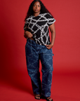 Meghna is wearing Mid-Rise Carpenter Jeans in Chain Link and black Chain Vintage Tee