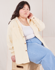 Ashley is wearing Corduroy Overshirt in Vintage Off-White with a vintage off-white Cropped Tank Top underneath and light wash Denim Trousers