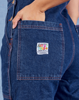 Indigo Denim Original Overalls in Dark Wash back pocket close up. Tiara has her hand in the pocket.