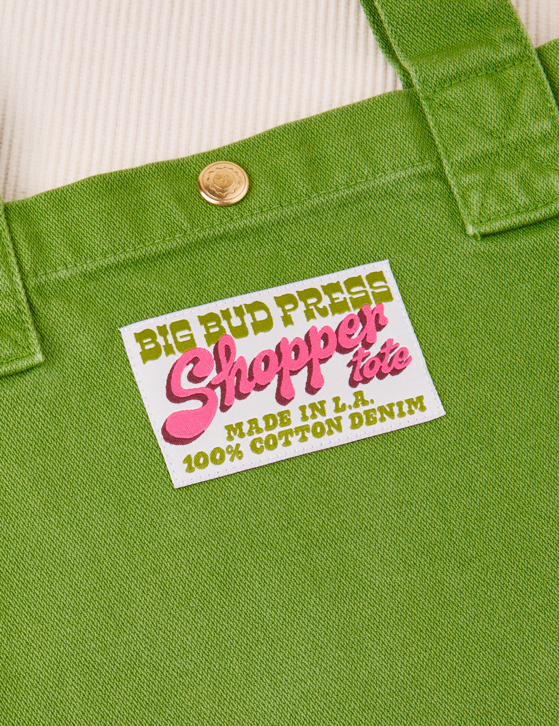 Sun baby brass snap on Shopper Tote Bag in Bright Olive. Bag label with green and pink text that reads "Big Bud Press Shopper Tote, Made in L.A., 100% Cotton Denim on white background