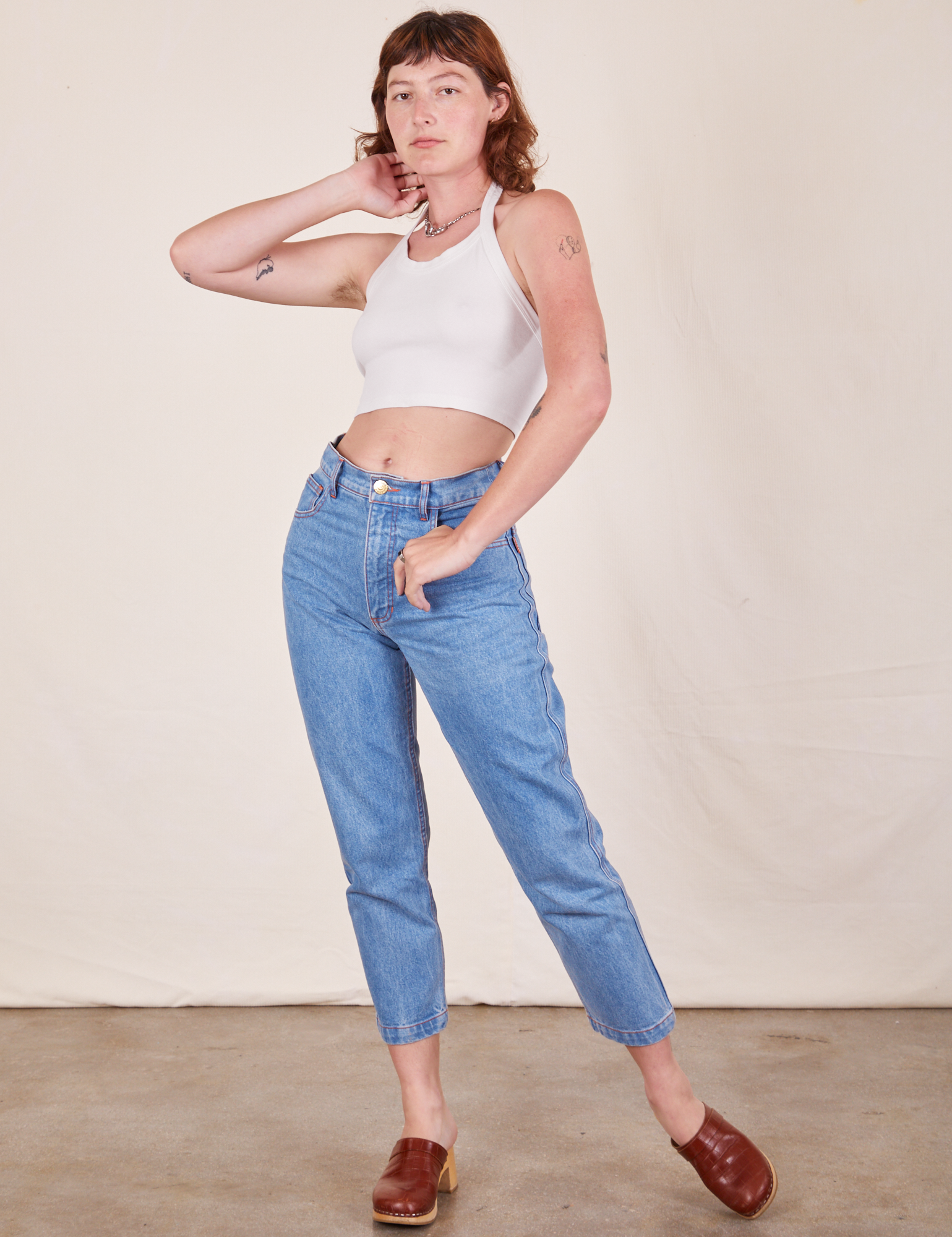 Alex is wearing Halter Top in Vintage Off-White and light wash Frontier Jeans