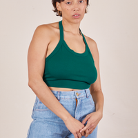 Tiara is 5'4" and wearing XS Halter Top in Hunter Green paired with light wash Sailor Jeans