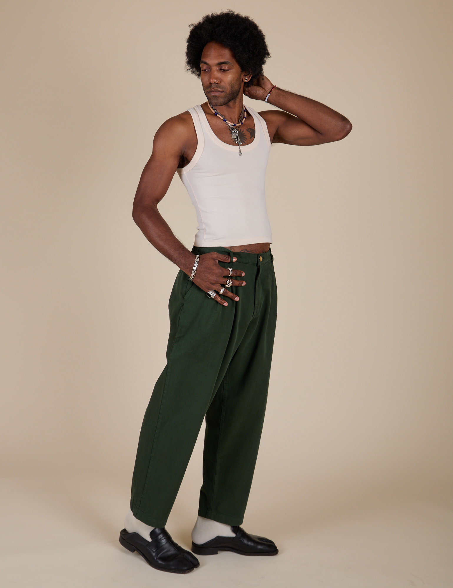 Angled front view of Heavyweight Trousers in Swamp Green and Tank Top in Vintage Tee Off-White on Jerrod