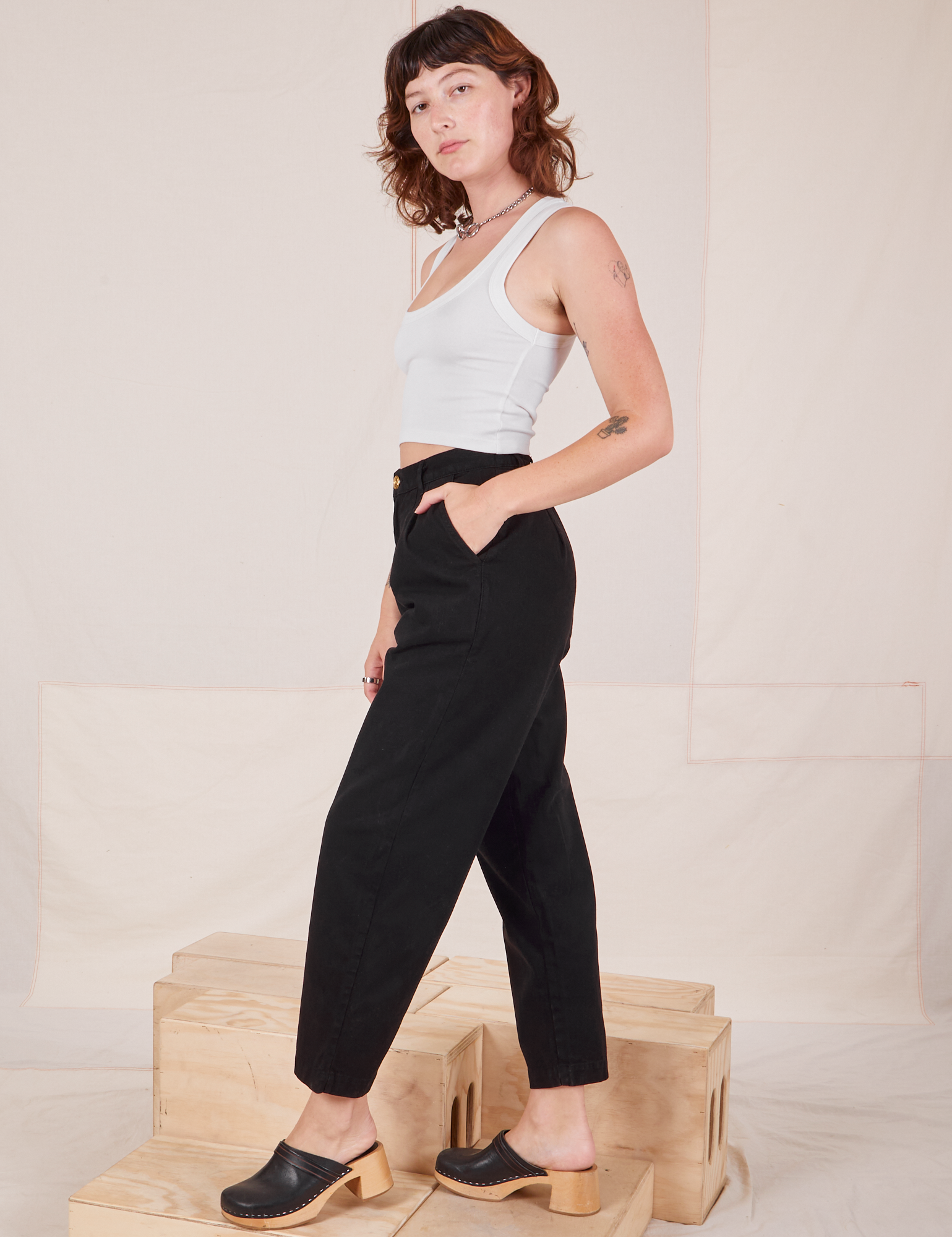 Side view of Heavyweight Trousers in Basic Black and vintage off-white Cropped Tank Top worn by Alex.