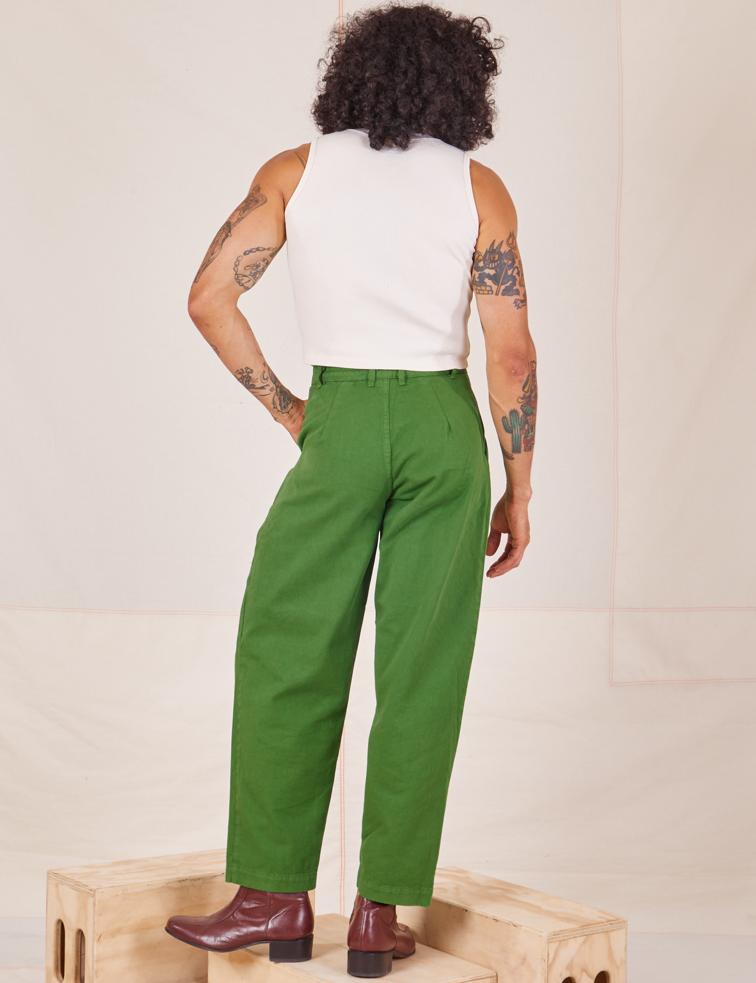 Back view of Heavyweight Trousers in Lawn Green and vintage off-white Sleeveless Turtleneck worn by Jesse