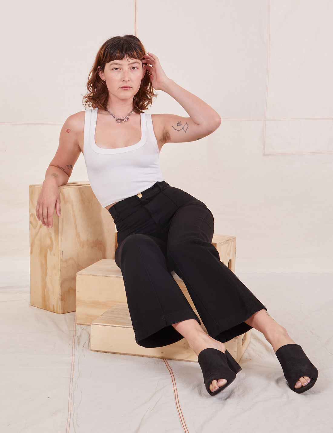 Alex is wearing Heritage Westerns in Basic Black and a Cropped Tank Top in vintage off-white