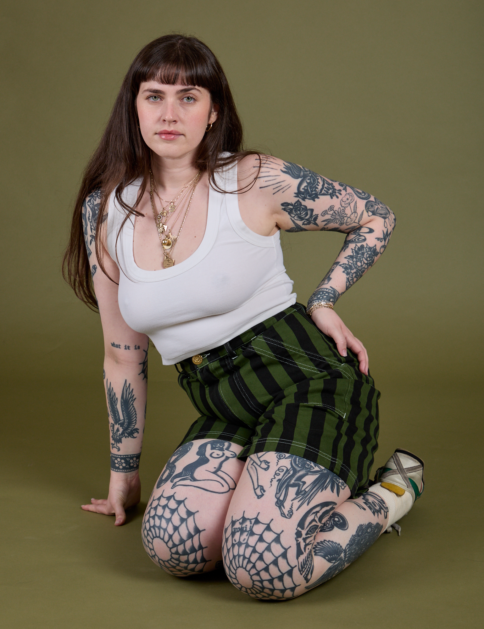 Sydney is wearing Longline Work Shorts in Evergreen and vintage tee white Cropped Tank