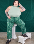 Sam is wearing Marble Splatter Work Pants in Hunter Green and sage green Sleeveless Turtleneck