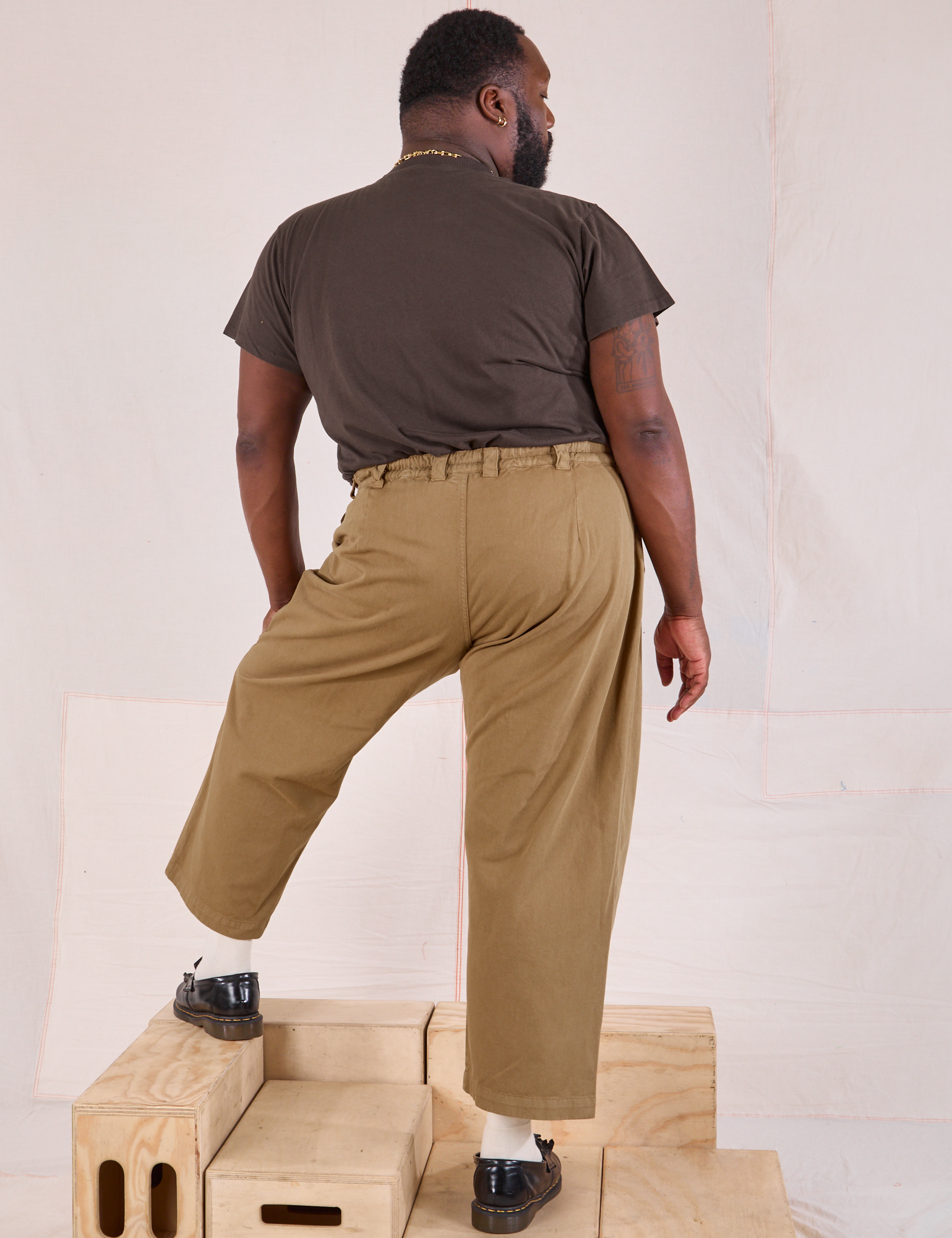 Back view of Mid-Rise Pleated Trousers in Desert Brown and espresso brown Organic Vintage Tee