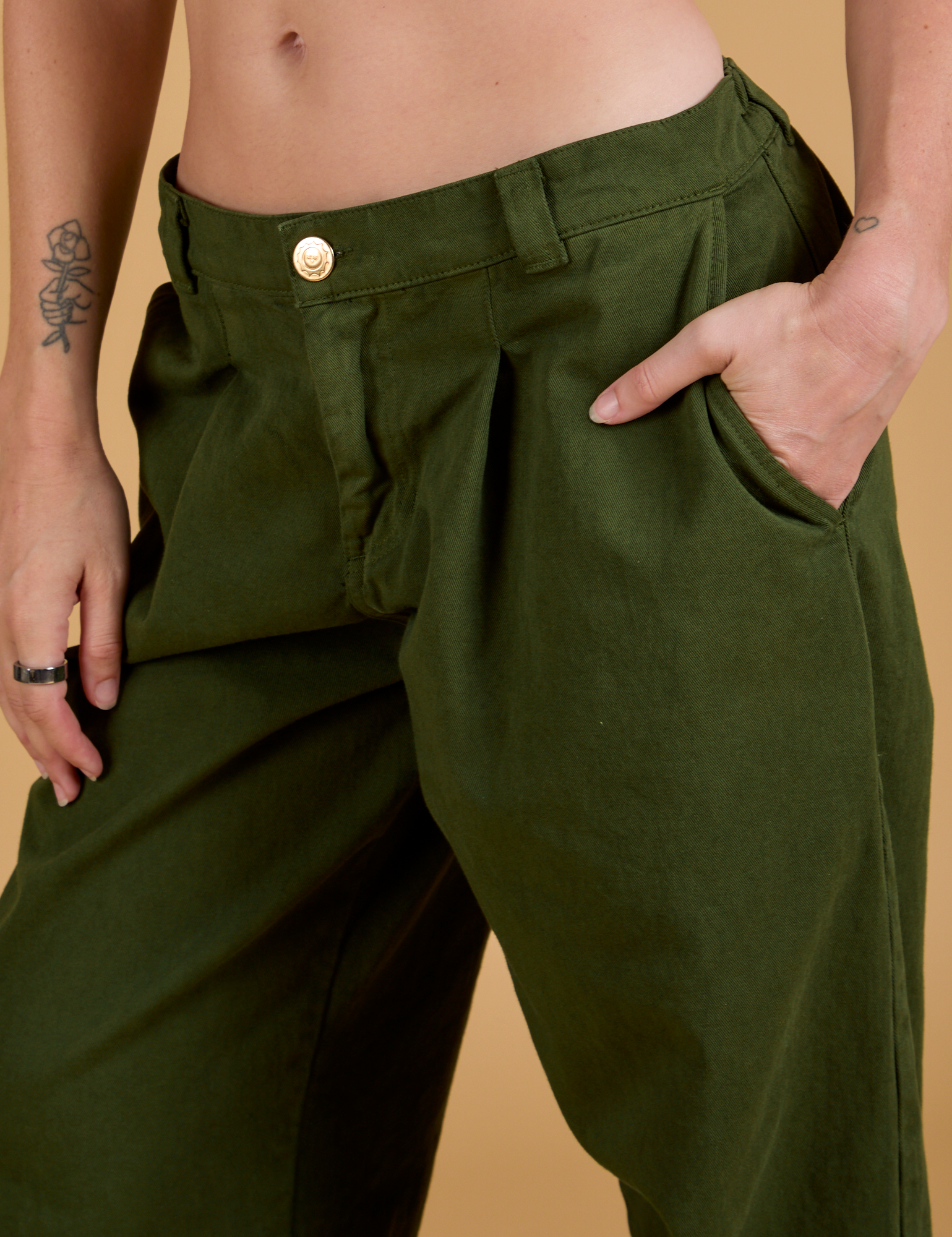 Close up of Alex&#39;s hand in the front pocket of Baggy Mid-Rise Trousers in Evergreen