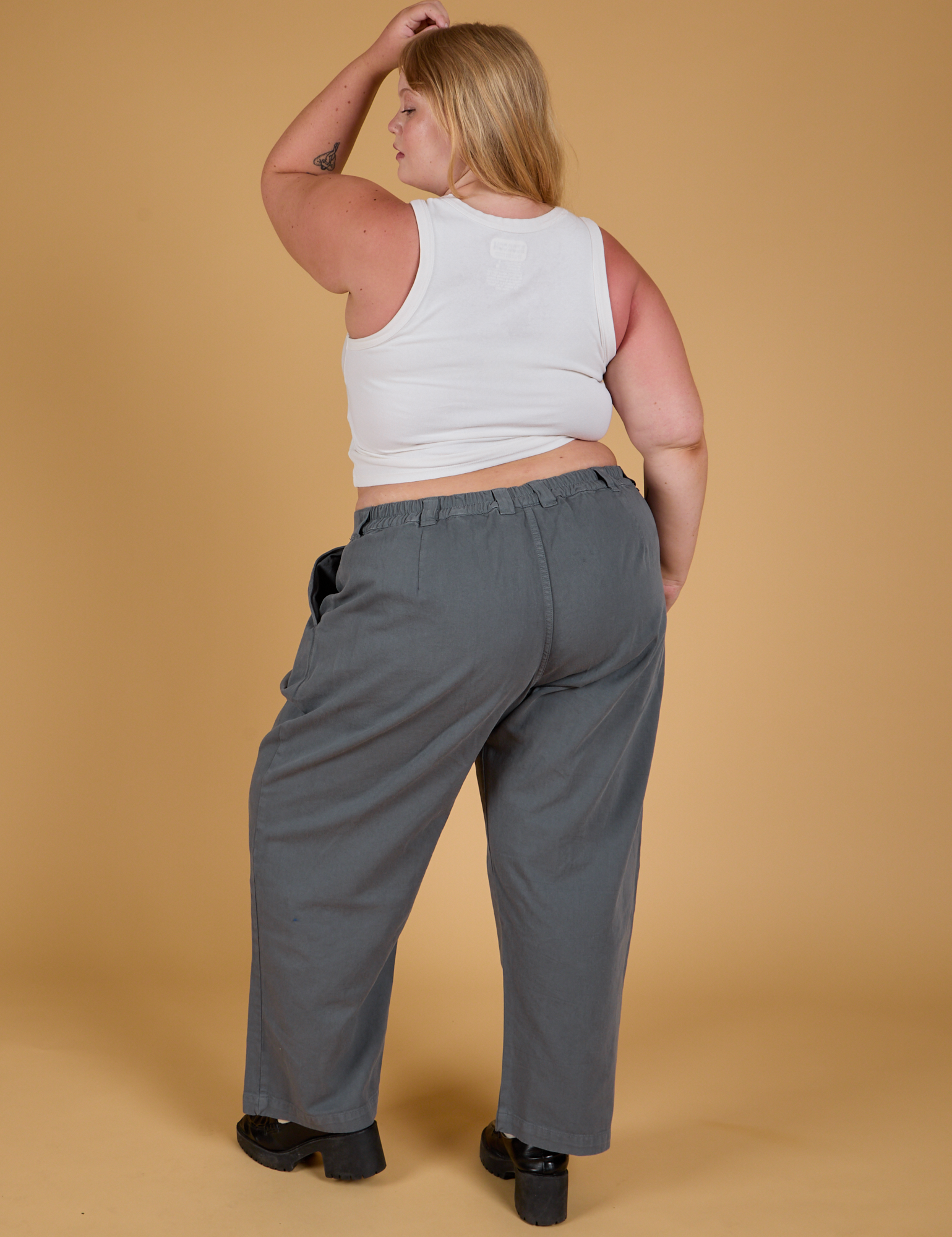 Back view of Baggy Mid-Rise Trousers in Slate Grey and vintage tee white Cropped Tank on Juliet