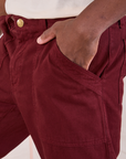 Mid-Rise Work Pants in Red Wine close up of Issac's hand in the front pocket