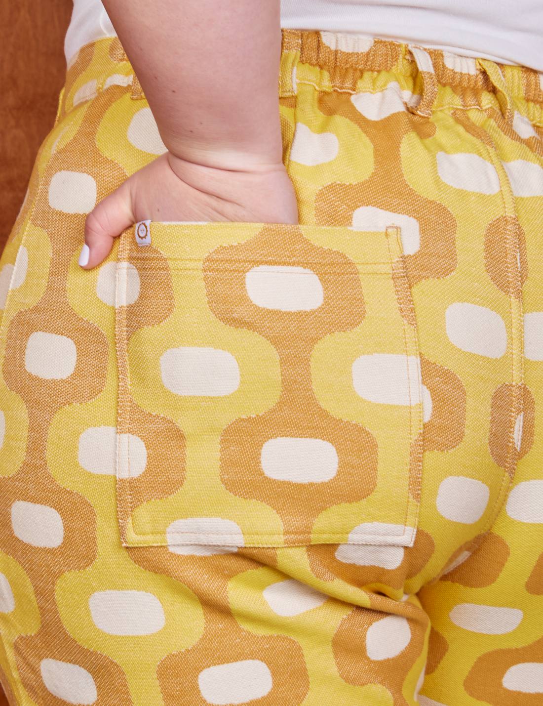 Back pocket close up of Western Pants in Yellow Jacquard. Ashley has her hand in the pocket.
