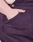 Front pocket close up of Original Overalls in Mono Nebula Purple. Catie has her hand in the pocket.