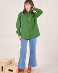 Hana is wearing a buttoned up Oversize Overshirt in Lawn Green paired with light wash Sailor Jeans