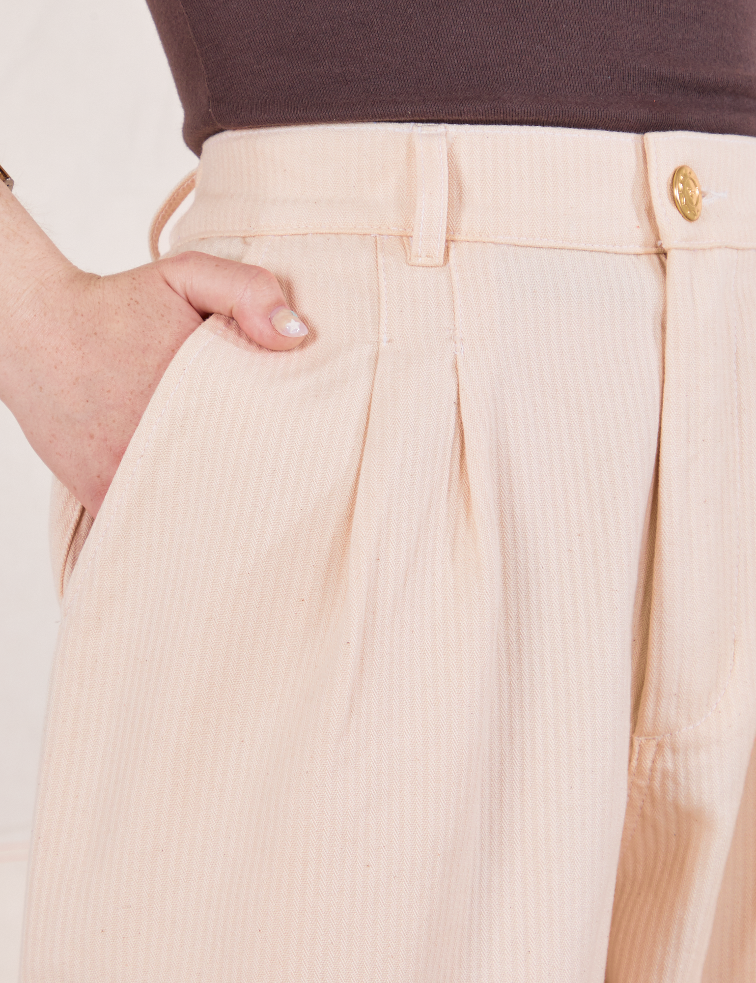 Heritage Trousers in Vintage Off-White front close up. Hana has her hand in the pocket.