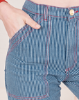 Front close up of Railroad Stripe Denim Work Pants. Alex has her hand in the pocket.