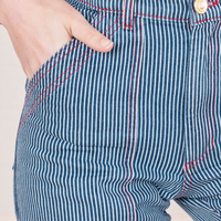 Front close up of Railroad Stripe Denim Work Pants. Alex has her hand in the pocket.