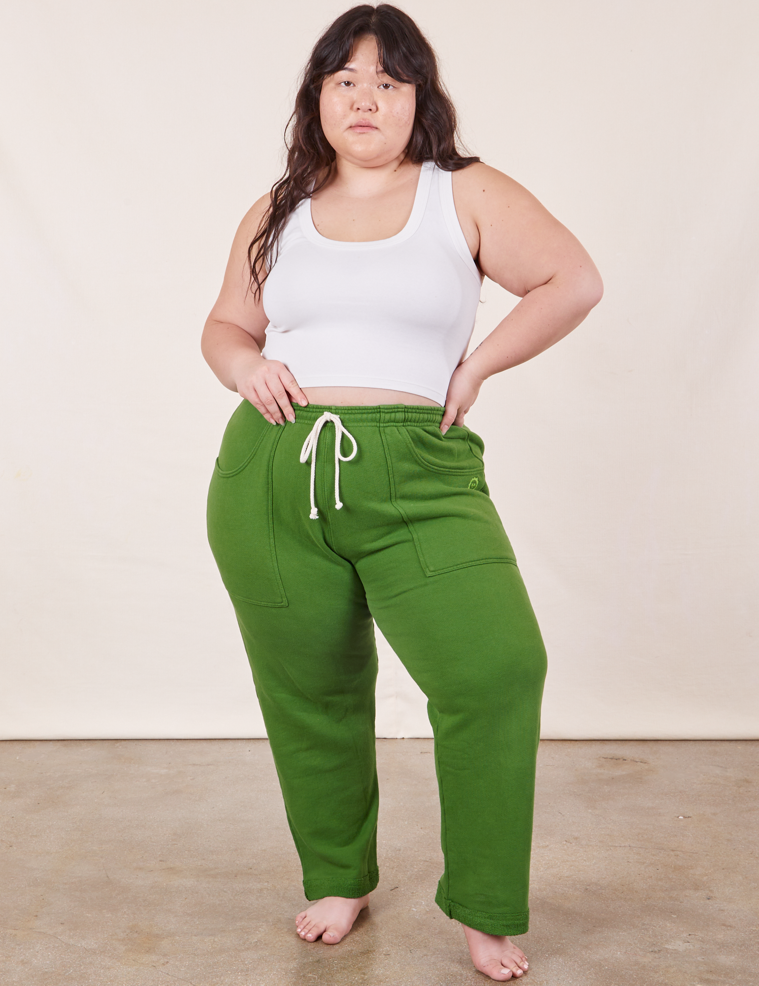 Ashley is 5&#39;7&quot; and wearing XL Cropped Rolled Cuff Sweatpants in Lawn Green paired with vintage off-white Cropped Tank Top