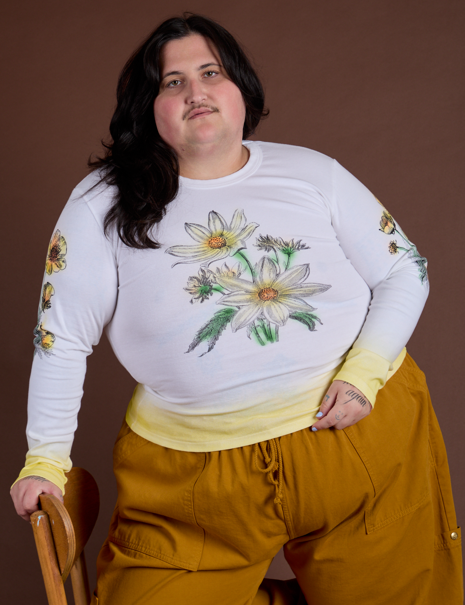 Sam is wearing Floral Long Sleeve Baby Tee in Yellow 