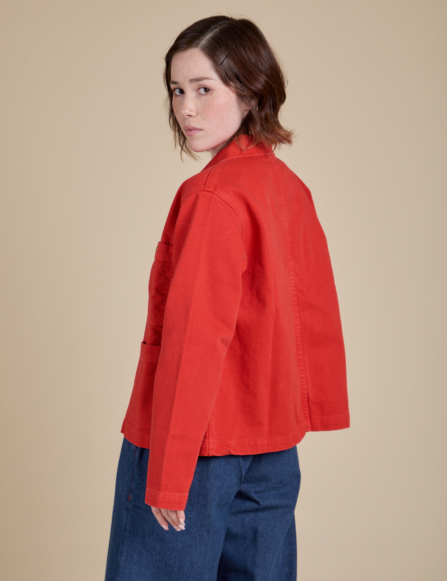 Angled back view of Denim Work Jacket in Mustang Red on Hana