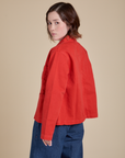 Angled back view of Denim Work Jacket in Mustang Red on Hana