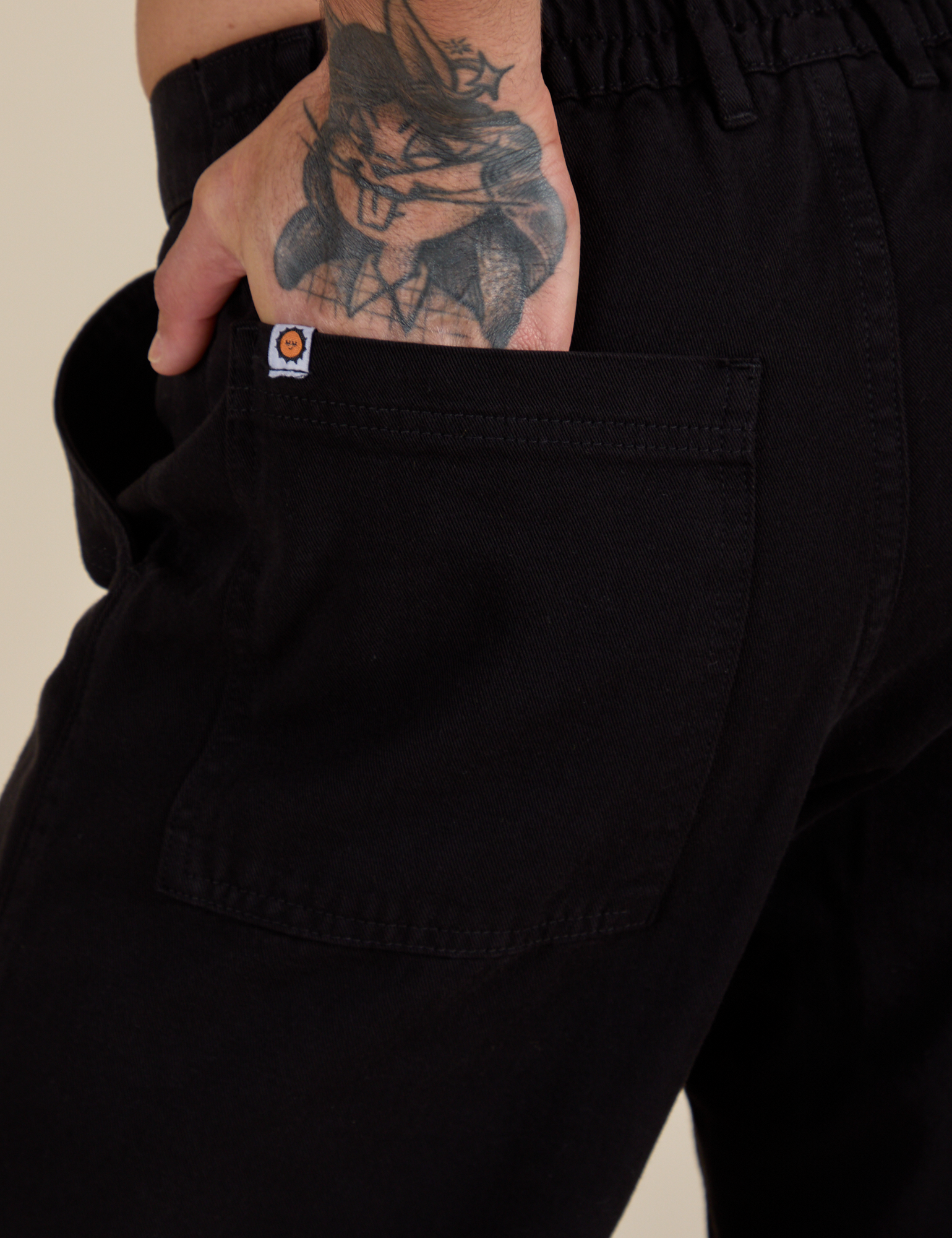 Close up of Jesse's hand in the back pocket of Work Pants in Basic Black