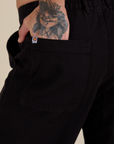 Close up of Jesse's hand in the back pocket of Work Pants in Basic Black