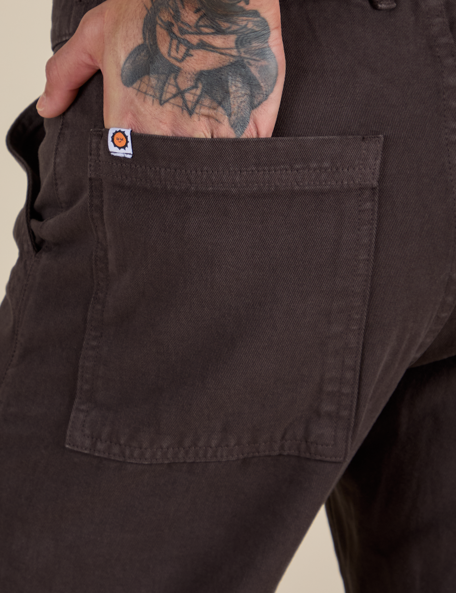 Close up of Jesse's hand ithe back pocket of Work Pants in Espresso Brown