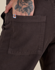 Close up of Jesse's hand ithe back pocket of Work Pants in Espresso Brown