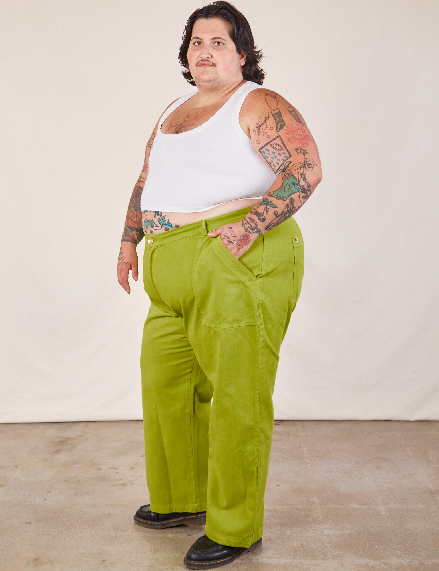 Side view of Work Pants in Gross Green and Cropped Tank in vintage tee off-white on Sam