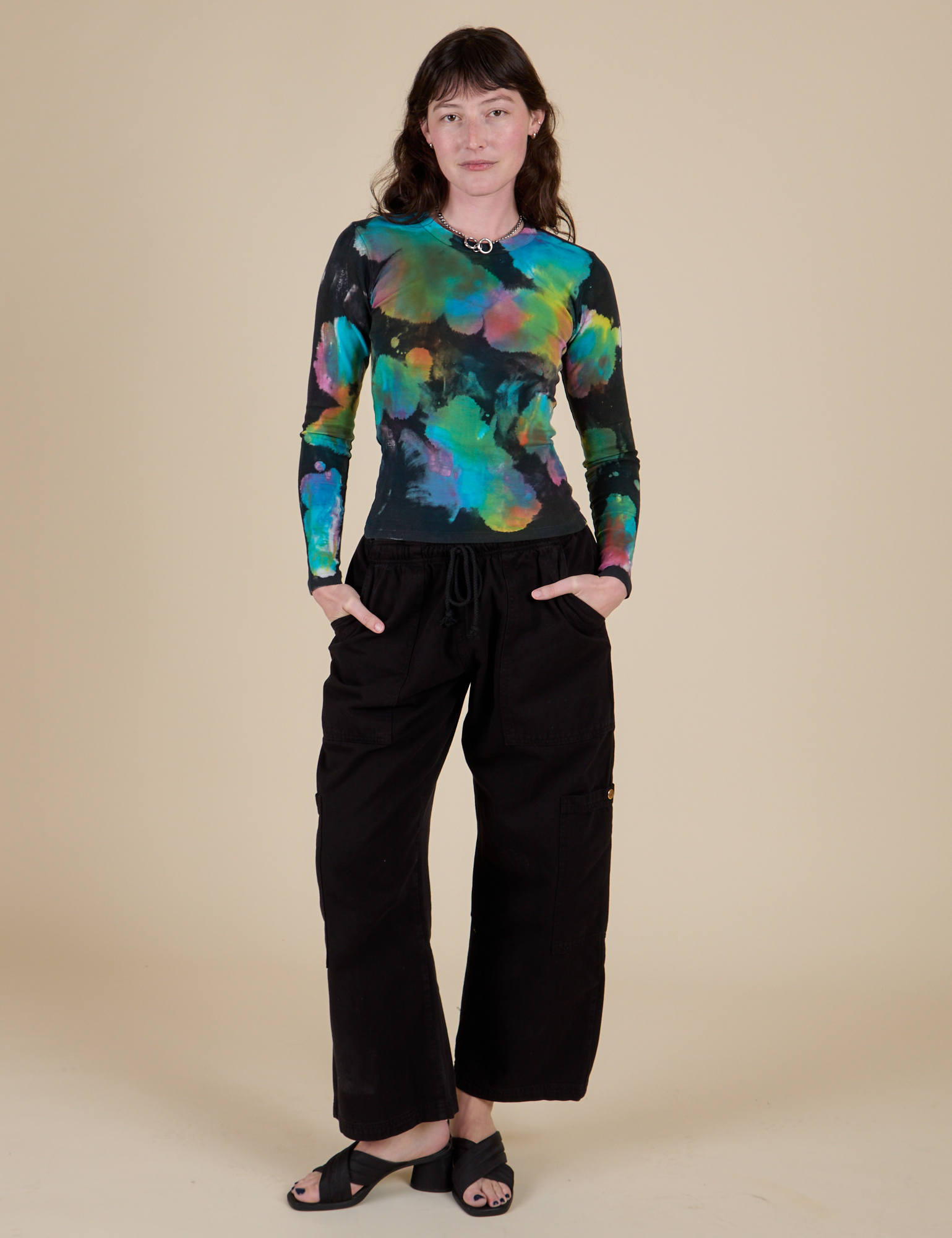 Alex is wearing Long Sleeve Baby Tee in Rainbow Magic Waters paired with black Drop Pocket Cargo Pants