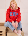 Margaret is wearing Collegiate Hoodie in Mustang Red