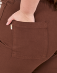 Bell Bottoms in Fudgesicle Brown back pocket close up. Marielena has her hand in the pocket.