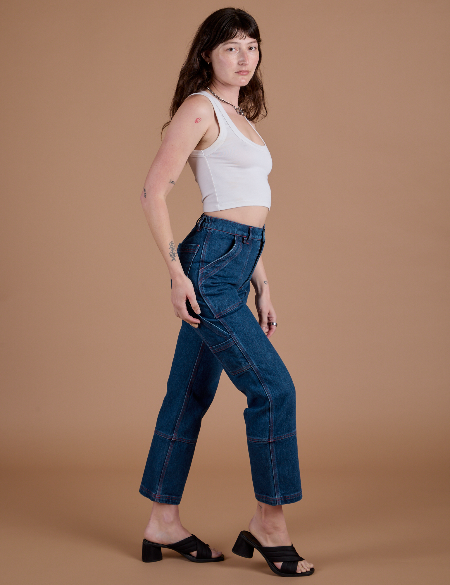 Side view of Carpenter Jeans in Dark Wash and Cropped Tank in Vintage Tee White on Alex