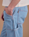 Close up of Quinn's hand in the front pocket of Carpenter Jeans in Light Wash