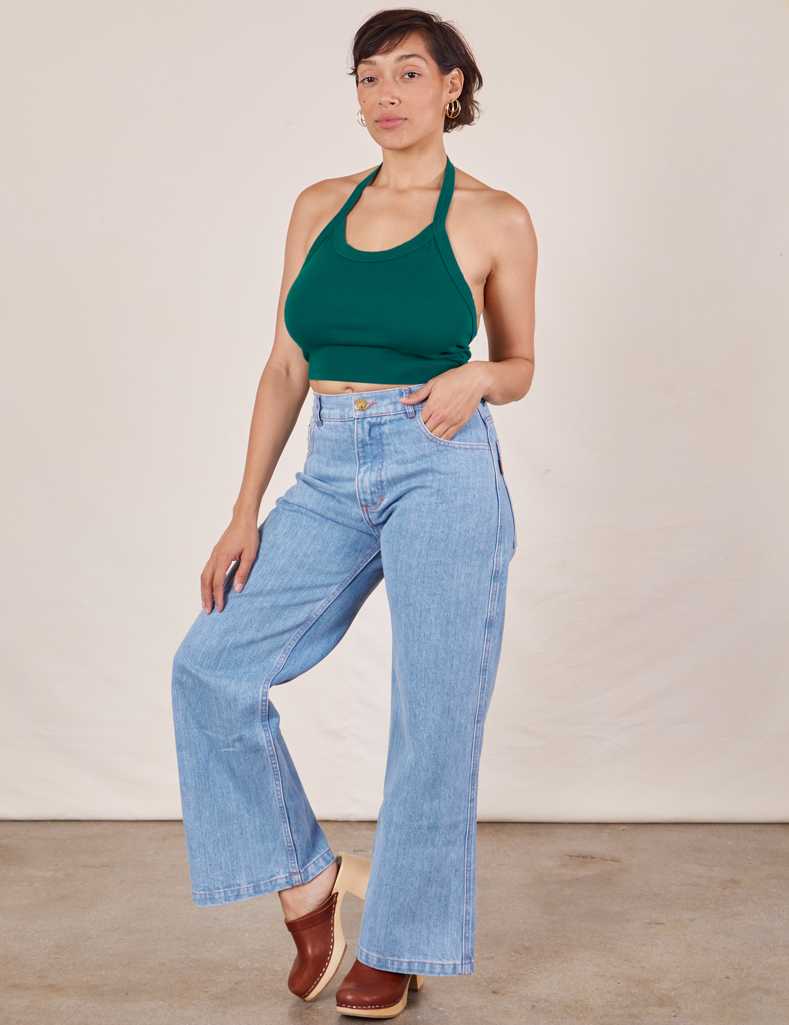 Tiara is wearing Halter Top in Hunter Green and light wash Sailor Jeans