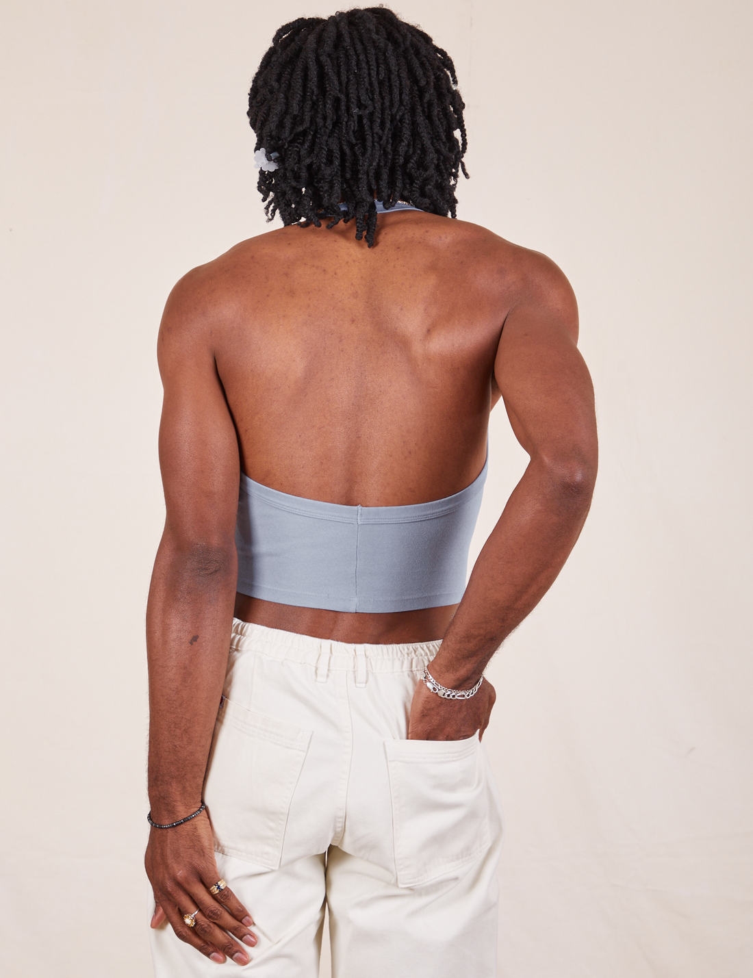 Back view of Halter Top in Periwinkle and vintage off-white Western Pants worn by Jerrod. They have their left hand in the pant back pocket.